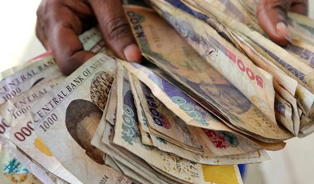 Counting old Nigerian Naira notes.