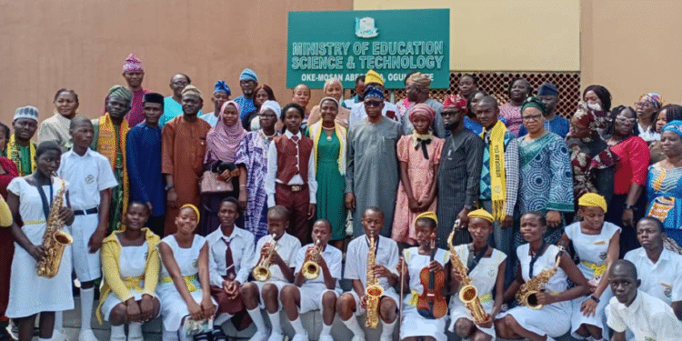 The Commissioner for Education, Science and Technology, Prof Abayomi Arigbabu in group photograph with 16-year-old one-day Comissioner and SS3 student of African Grammar School, Ita Iyalode, Abeokuta, Alaka Oluwagbemisoke alongside other students of the school and officials of the ministry. Credit: Taiwo Bankole: